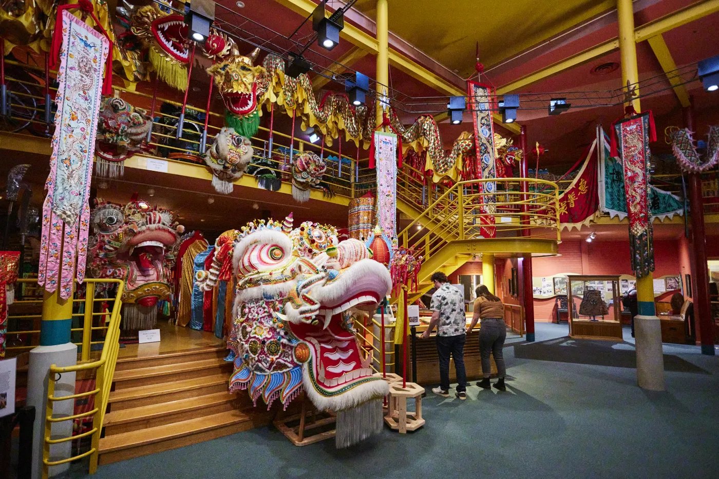 A large, colorful dragon sculpture dominates the center of the space, with people nearby.